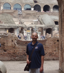 Mikel inside the Colosseum with a messenger bag